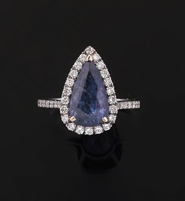 a blue sapphire and diamond ring on a black surface
