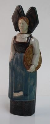 une figurine en céramique représentant une femme portant un panier sur l'épaule