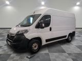 la camionnette blanche est garée sur un sol carrelé en damier