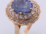 a close up of a ring with a blue sapphire and white diamonds