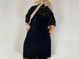 an old fashioned doll is posed on a white surface