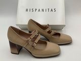 a pair of beige shoes with a box in the background