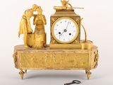 une horloge en or posée sur une table, avec une clé