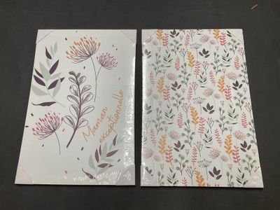 deux cartes de vœux ornées de motifs floraux, posées sur une table