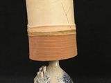 a white and blue lamp with a brown shade on it