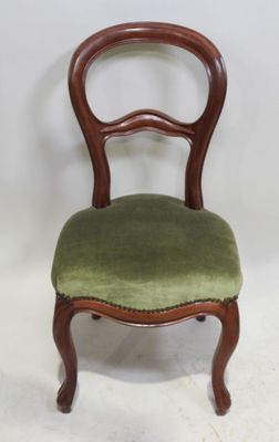 une image représentant une chaise dont l'assise est recouverte d'un tissu vert, sur fond blanc