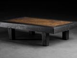 une photo d'une table en bois avec un plateau marron posée sur un sol en béton