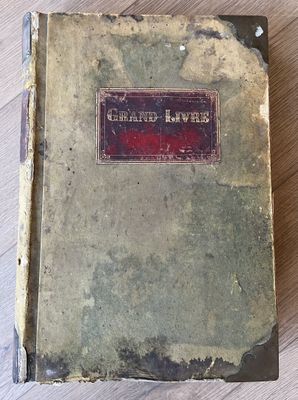 un vieux livre posé sur une table en bois à côté d'une tasse de café