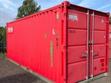 red shipping container sitting in a parking lot on a sunny day