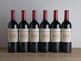 six bouteilles de vin rouge sont alignées sur une table en bois