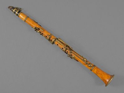 an old clarinet with a wooden handle on a gray surface