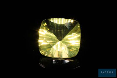 a close up of a yellow diamond on a black surface