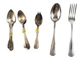 five spoons, two forks, and a spoon on a white surface