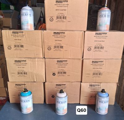 several cans of paint sitting on top of a table next to a stack of boxes