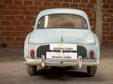 a old car that is parked in front of a brick wall