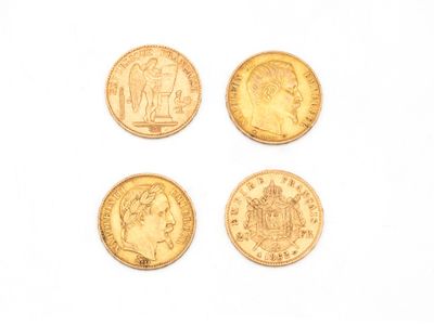 quatre types différents de pièces d'or reposant sur une surface blanche