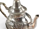a silver tea pot with a lid on a white surface