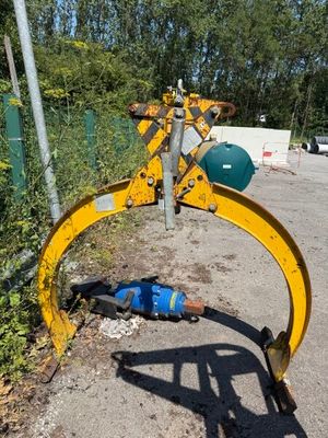 a blue ball laying on the ground next to a yellow bulldozer