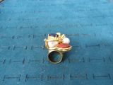 a gold ring with a pink and blue stone on it