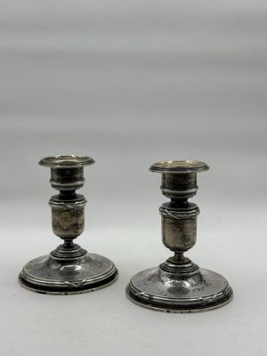pair of antique silver candlesticks on a white background