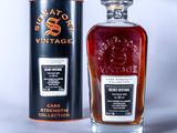a bottle of whisky sitting next to a canister of whisky