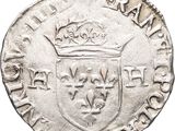 a close up of a silver coin with a crown on it