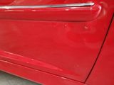 a close up of a red car door handle