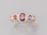 une bague à trois pierres, composée d'un saphir rose, d'un saphir bleu et d'un diamant