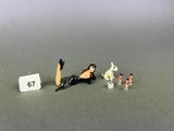 une figurine représentant une femme assise sur une table, à côté d'un chiffre