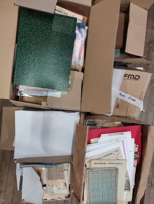 a box full of papers sitting on the floor next to a pile of books