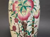 a white vase with a painting of peaches on it