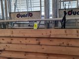un gros tas de bois dans un bâtiment, sur lequel sont accrochées des pancartes