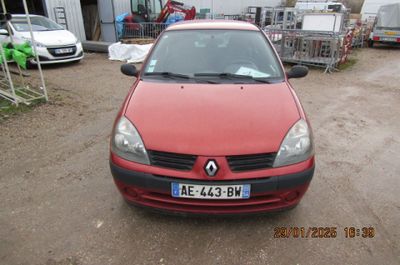 une voiture rouge garée sur un parking, avec d'autres voitures en arrière-plan