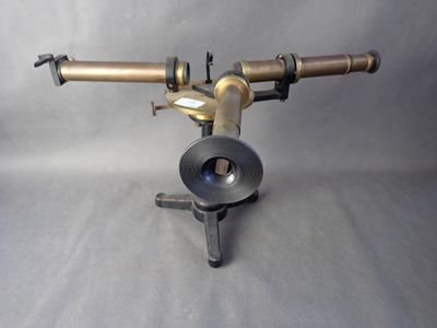 un petit télescope posé sur un trépied, lui-même posé sur une table