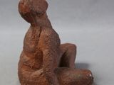 a small figurine of a man sitting on the ground
