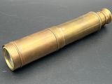 an old brass telescope on a black surface