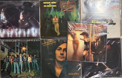 many different album covers on the wall of a room