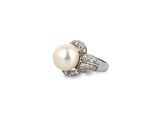 a white pearl and diamond ring on a white background