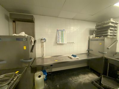une cuisine avec de nombreux plans de travail en inox