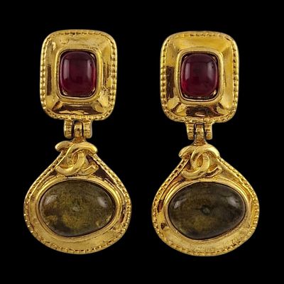 une paire de boucles d'oreilles en or ornées de pierres rouges et vertes