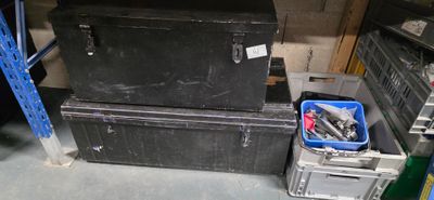 deux boîtes noires et une poubelle bleue dans un garage