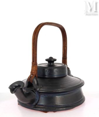a black tea kettle with a wooden handle on a white surface