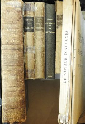 Plusieurs vieux livres sont empilés sur une étagère dans une bibliothèque