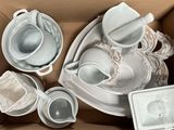 a lot of white dishes and cups in a box