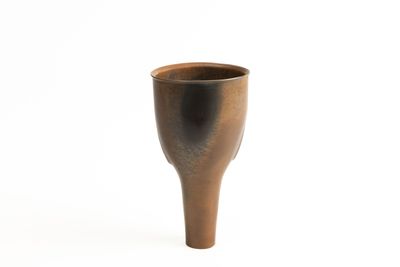a brown cup that is sitting on a white surface