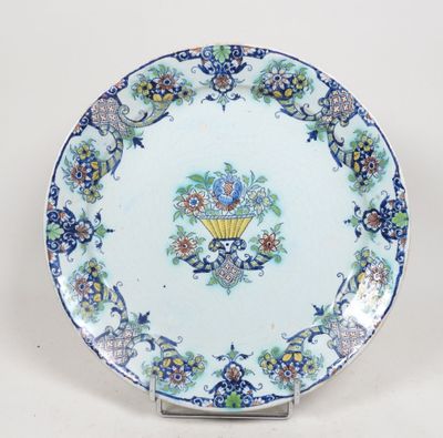 une assiette bleue et blanche ornée de fleurs et d'un éventail
