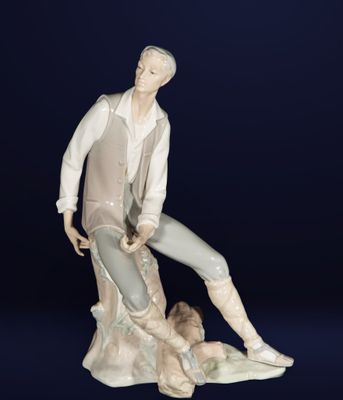 figurine en porcelaine représentant un homme assis sur un rocher avec un chien