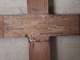 a wooden cross with writing on it in a room