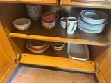 une armoire en bois sur laquelle sont posées des assiettes et des tasses
