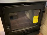 un poêle noir sur lequel est collé un autocollant jaune
